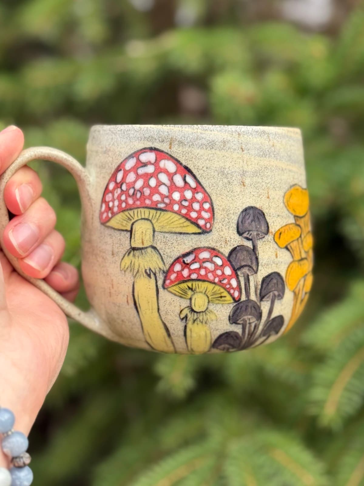 Hand painted mushroom ceramic mug with whimsical toadstool design on cream stoneware