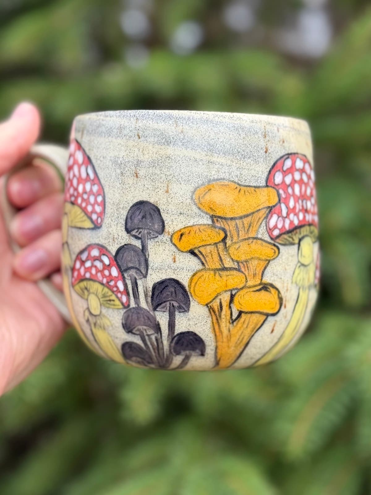 Hand painted mushroom ceramic mug with whimsical toadstool design on cream stoneware