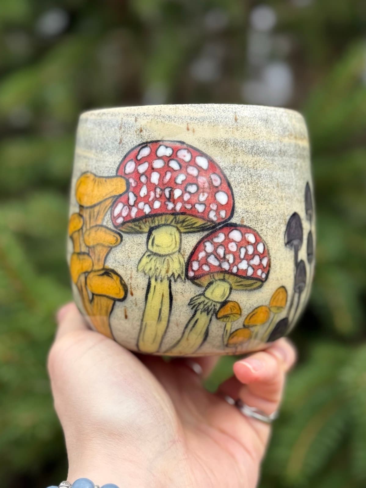 Hand painted mushroom ceramic mug with whimsical toadstool design on cream stoneware