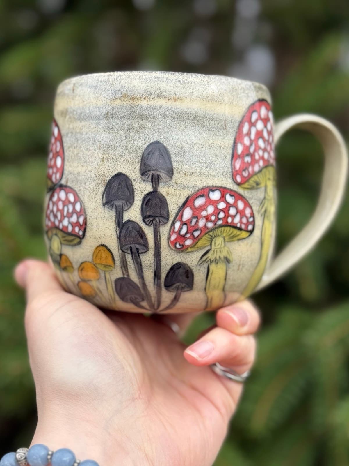 Hand painted mushroom ceramic mug with whimsical toadstool design on cream stoneware