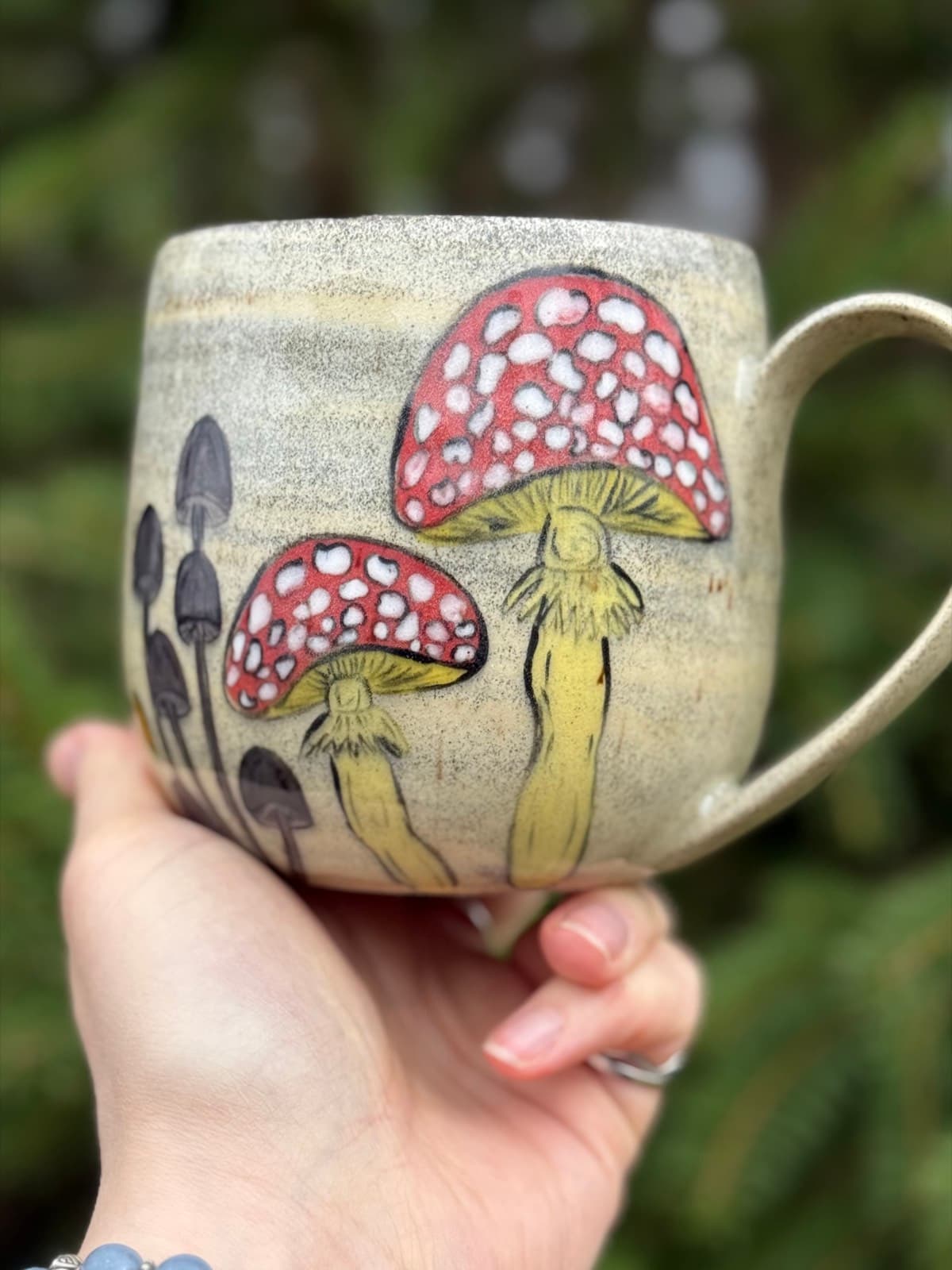 Hand painted mushroom ceramic mug with whimsical toadstool design on cream stoneware